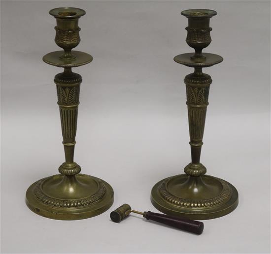 A pair of bronze candlesticks together with French candle snuffer height 26cm